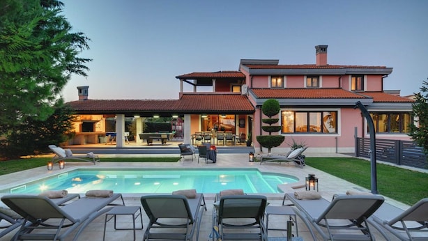 A modern house with a swimming pool, outdoor seating, and a covered patio area. - Gorgeous 5-BR Villa with private heatable pool near Pula (Fažana)