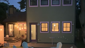 A two-story house with a patio area featuring outdoor seating and a fire pit.