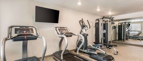 A gym with treadmills, a stationary bike, and weight machines.