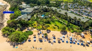 Eine Luftaufnahme eines Resorts mit Strand, Palmen und einem Golfplatz.