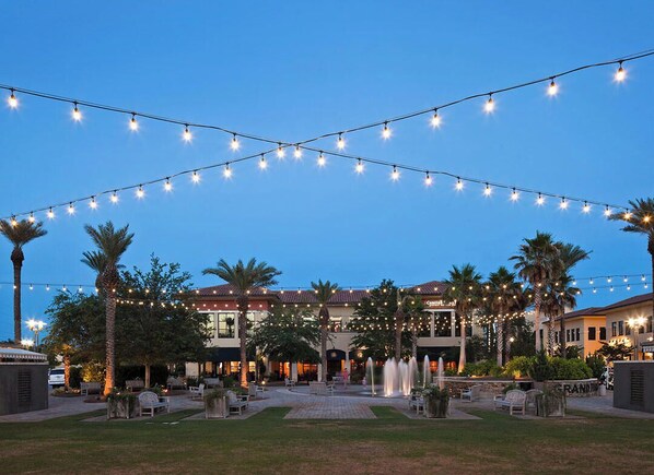 An outdoor patio area with string lights, palm trees, and a fountain. - Seas The Day, House, Priv Pool & Beach, Golf Cart (Miramar Beach)