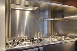 A stainless steel kitchen with a gas stove, a built-in sink, and a range hood. - UR-NEST Moline, Stunning Apartment (Bologna)