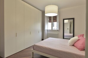 A bedroom with a bed, a wardrobe, a mirror, and a window. - UR-NEST Moline, Stunning Apartment (Bologna)