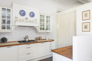 A kitchen with white cabinetry, a gas stove, and blue decorative plates on the wall. - UR-NEST Fusari, Wonderful apartment  (Bologna)