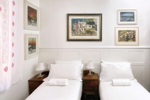 A hotel room with two beds, white bedding, and framed artwork on the walls. - UR-NEST Fusari, Wonderful apartment  (Bologna)