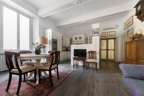 A spacious living room with a dining area, a television, and a sofa. - UR-NEST Fusari, Wonderful apartment (Bologna)