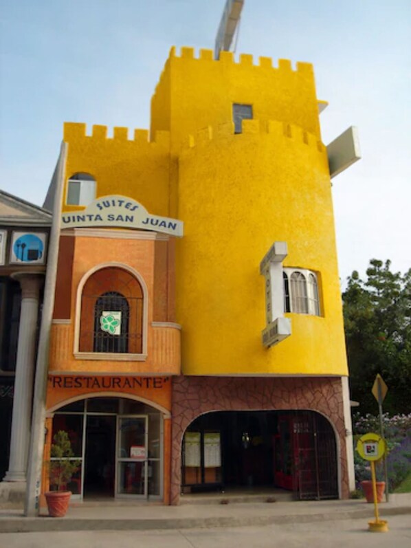 A building with a yellow facade, a sign for 'SUITES QUINTA SAN JUAN', and a 'RESTAURANTE' sign. - Hotel Quinta San Juan (Ciudad Valles)