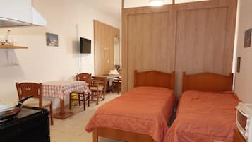 Una camera da letto con due letti, una scrivania, una sedia, una TV e un forno a microonde.
