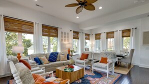 A spacious living room with a large ceiling fan, a sofa set, a coffee table, and a dining area with chairs. - Luxury@Dwell /Rooftop With Views/ Mins to Downtown (Nashville)