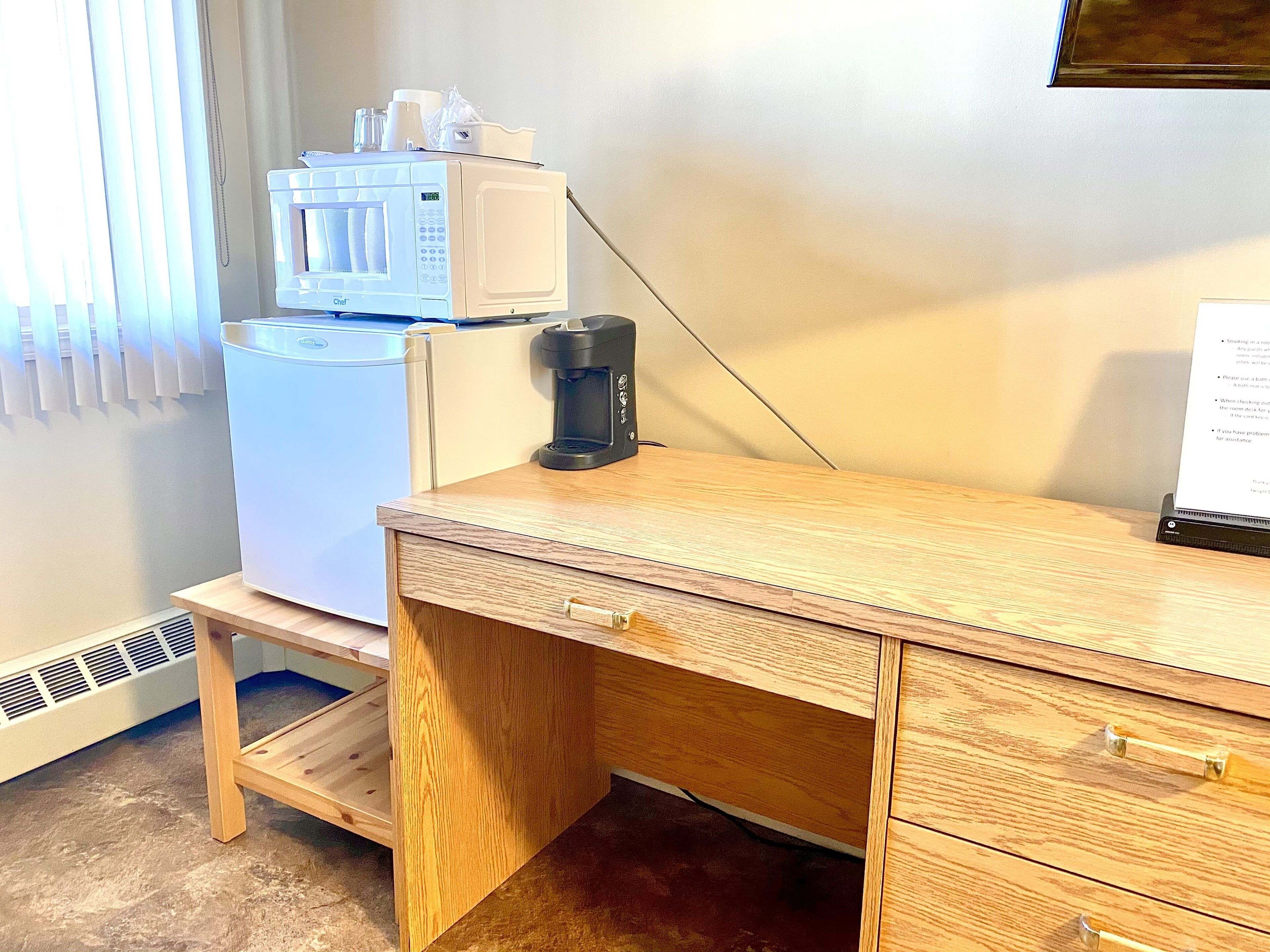 Una kitchenette equipada con microondas, cafetera y un refrigerador pequeño.