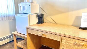 Una kitchenette equipada con microondas, cafetera y un refrigerador pequeño.