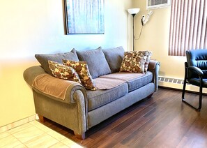 Suite Deluxe, 1 habitación | Área de sala de estar | Smart TV de 58 pulgadas con canales vía satélite