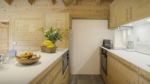 A modern kitchen with wooden cabinetry, a white countertop, and a stainless steel refrigerator. - Dorealp - superb apartment for 6 in peaceful setting - OVO Network (La Clusaz)