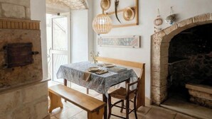 Un comedor rústico con banco, mesa y chimenea.