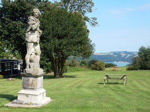 A statue in a grassy area with a bench and trees in the background. - Sheena's Dartmouth Chalets (Dartmouth)