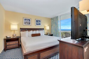 A hotel room with a large bed, two bedside tables with lamps, a television, and a view of the sea through a large window. - 2BR/2BA Unobstructed ocean view in Dunes Village (Myrtle Beach)