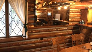 A log cabin interior with a dining table, chairs, a wooden ceiling, and a window with curtains. - Traverse City @ Rennie Lake  .. Idyllic Lakefront Retreat ..  CC49 ... Perfect! (traverse city)