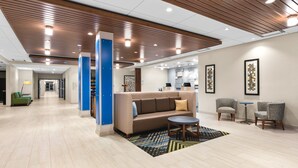 A modern lobby with a central seating area, a reception desk, and a hallway leading to other rooms. - Holiday Inn Express & Suites Suisun City by IHG (Suisun City)