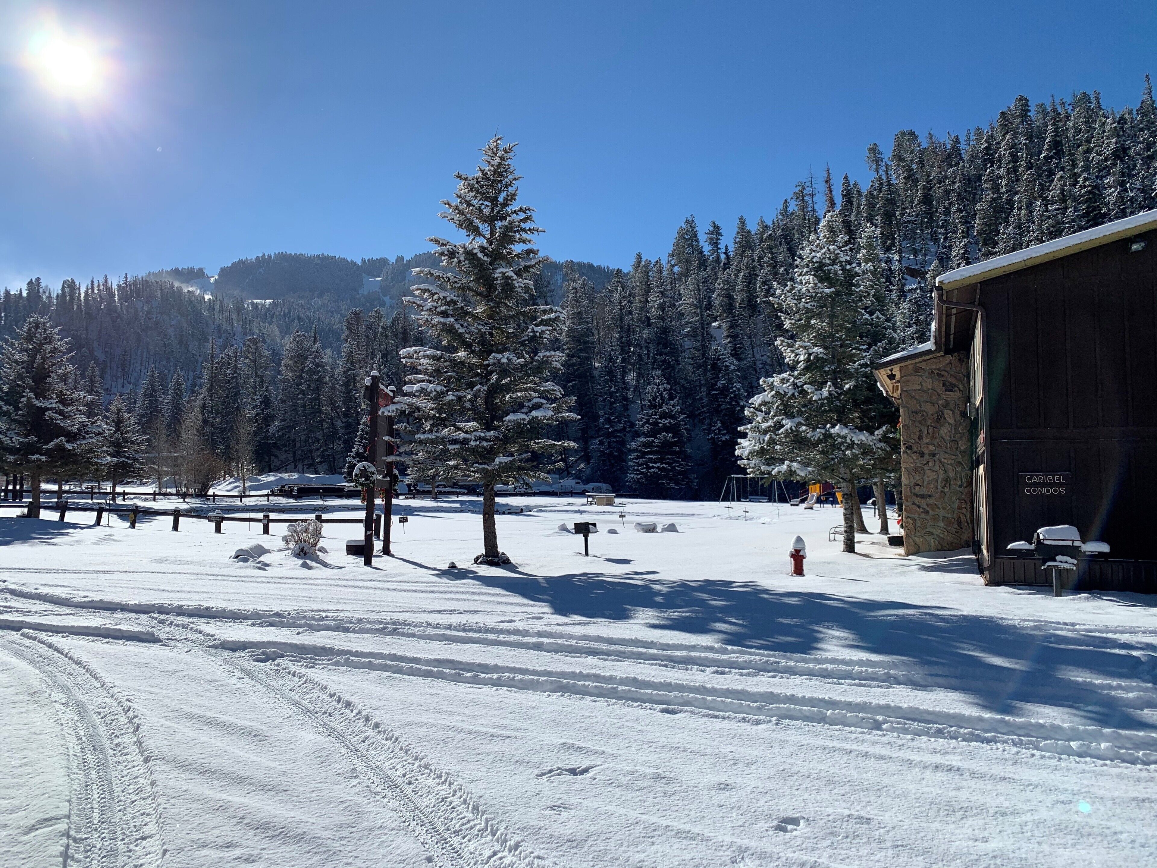 A snow-covered landscape with a building labeled 'CARIDEL CONDOS' and a clear sky.