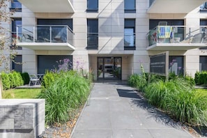 A modern building with a central entrance, two balconies, and a sign indicating 'APARTMENT LISS'.