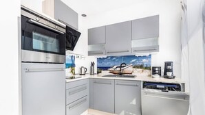 A modern kitchen with grey cabinets, a built-in oven, and a dishwasher.