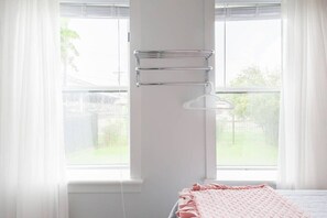Une chambre à coucher avec un lit, une fenêtre et un porte-serviettes.