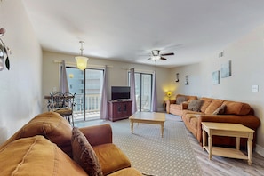 Relax in this stylish living room with a comfortable sofa, flat-screen TV, and ceiling fan.