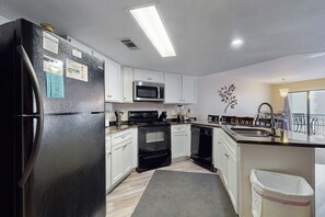 Enjoy cooking in this fully equipped kitchen with a refrigerator, oven, microwave, and sink.