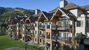 A row of multi-story buildings with balconies, set against a mountainous backdrop. - Luxury Ski in, Ski out 3 Bedroom Mountain Residence in the Heart of Lionshead Village with Heated Pool and Slopeside Hot Tub (Vail)