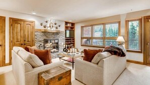 A cozy living room with two sofas, a coffee table, a fireplace, and a bookshelf. - Ski in, Ski out 3 Bedroom Mountain Residence in the Heart of Lionshead Village with Heated Slope Side Pool and Hot Tub (Vail)
