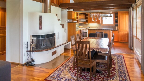 A spacious kitchen with a central island, wooden cabinets, and a large dining table with chairs. - Tahkon rummikub by Interhome (Nilsiä)