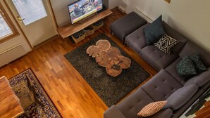 A modern living room with a grey sofa, a wooden coffee table, and a television on a stand. - Tahkon rummikub by Interhome (Nilsiä)