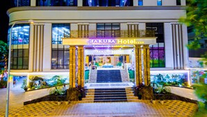A hotel entrance with a sign reading "SAKURA Hotel" and a staircase leading to the lobby. - Sakura Hotel (Hoa Binh)