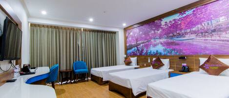 A hotel room with two single beds, a desk, a chair, a TV, and a large window with curtains.