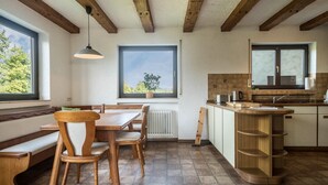 Cozinha com armários de madeira, bancada e janela com vista.
