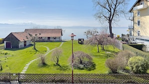 Une propriété au bord du lac, dotée d’un chalet de style traditionnel, d’une pelouse bien entretenue et offrant une vue dégagée sur le lac.