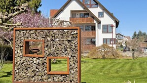Una casa moderna con techo inclinado, balcón y césped bien cuidado.