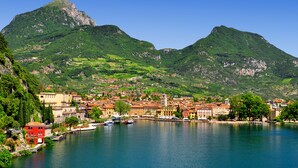 A coastal town with a prominent mountain, a harbor with boats, and buildings along the waterfront.