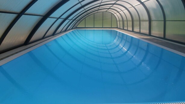 An indoor swimming pool with a curved ceiling and glass walls. - Wonderful private villa for 6 people with WIFI, pool, TV, terrace and pets allowed (Dvur Králové Nad Labem)