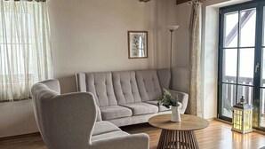 A living room with a grey sofa, a round wooden coffee table, and a potted plant. - Wonderful private villa for 6 people with WIFI, pool, TV, terrace and pets allowed (Dvur Králové Nad Labem)