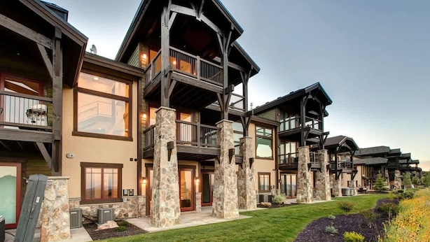A multi-story building with a stone facade, balconies, and large windows.