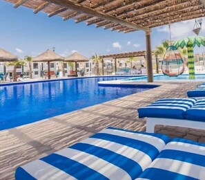 Un espace piscine équipé de chaises longues et de parasols.