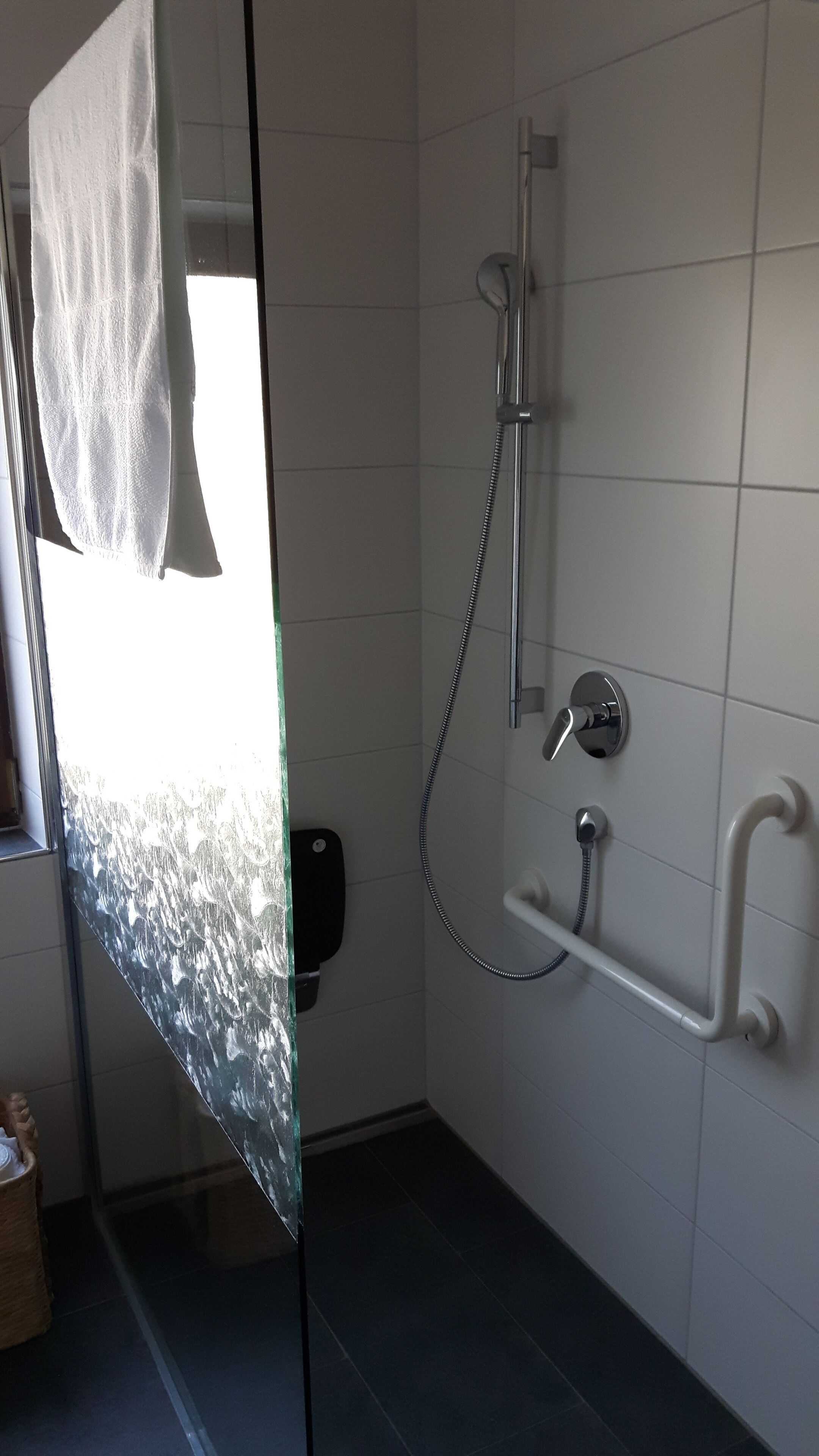 Een douche, handdoeken, zeep, toiletpapier