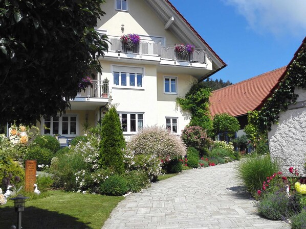 A multi-story building with a garden pathway leading to the entrance. - Ferienwohnung am Rosengarten (Ebermannstadt)
