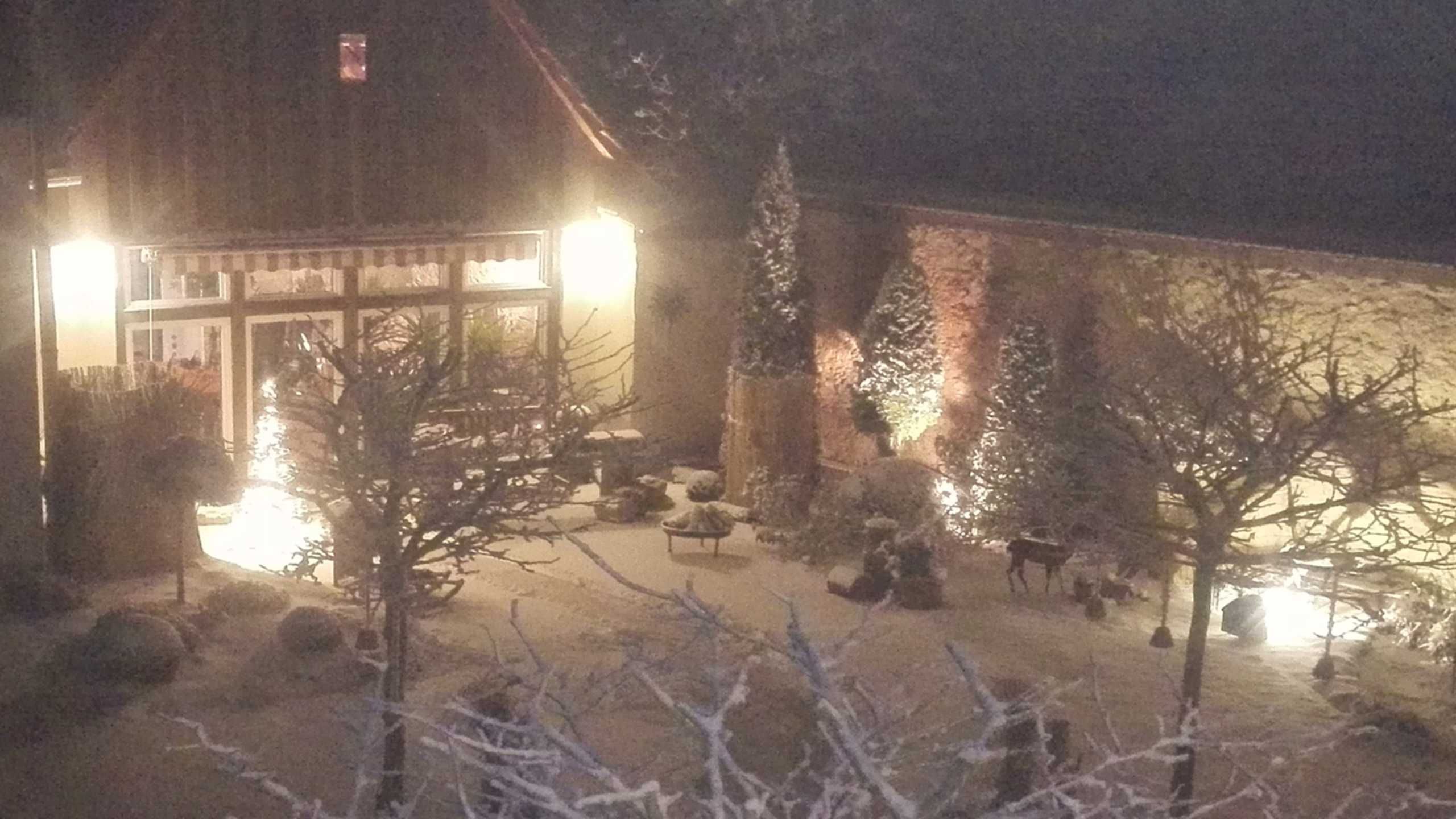 A building with a wooden facade, a glass entrance, and a snow-covered ground.