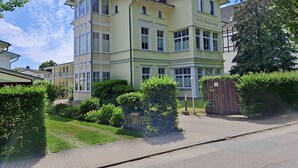 Ein mehrstöckiges Gebäude mit einer hellgrünen Fassade, zahlreichen Fenstern und einem verschlossenen Eingang.