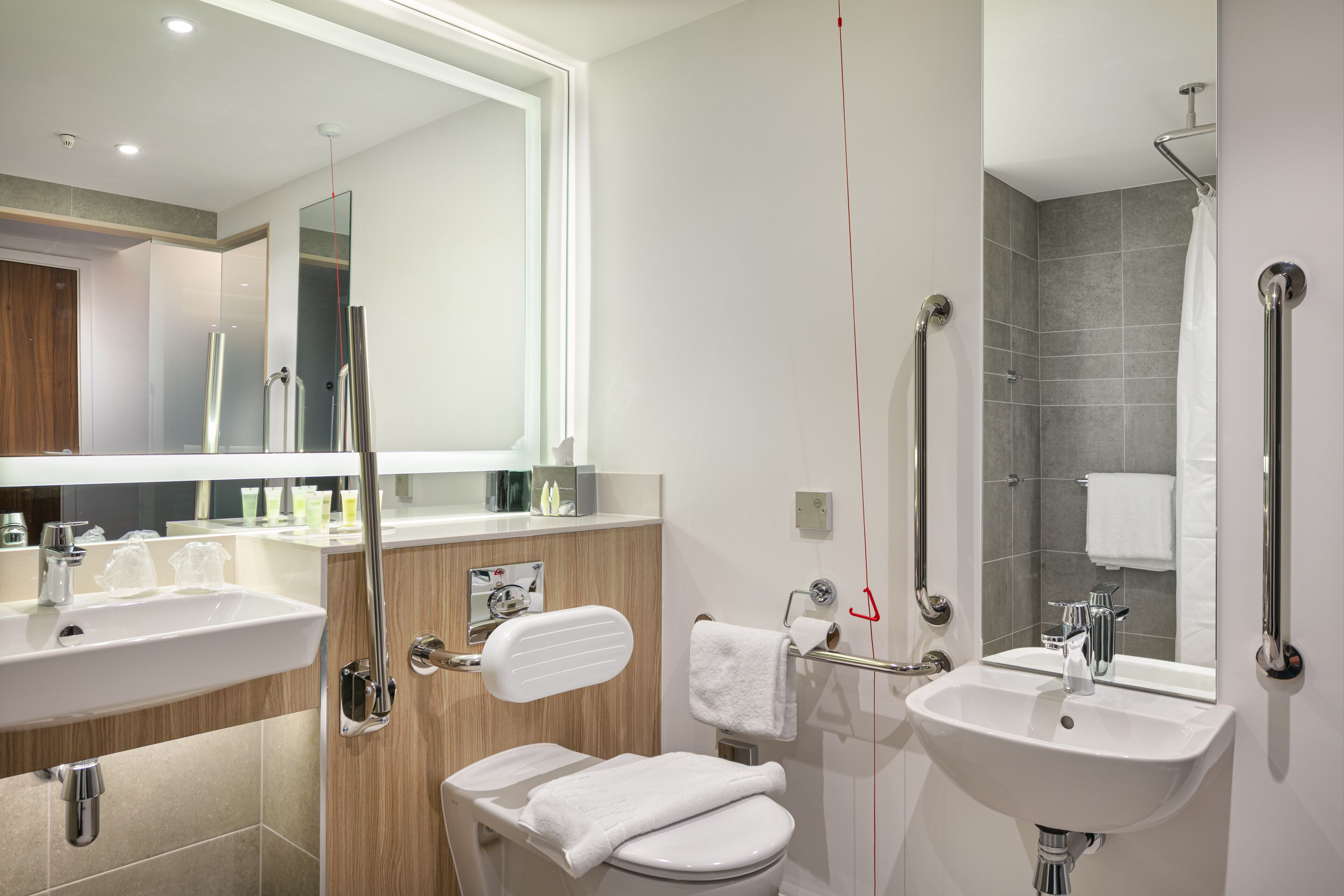 Une salle de bain moderne avec deux lavabos, des toilettes et un espace douche.