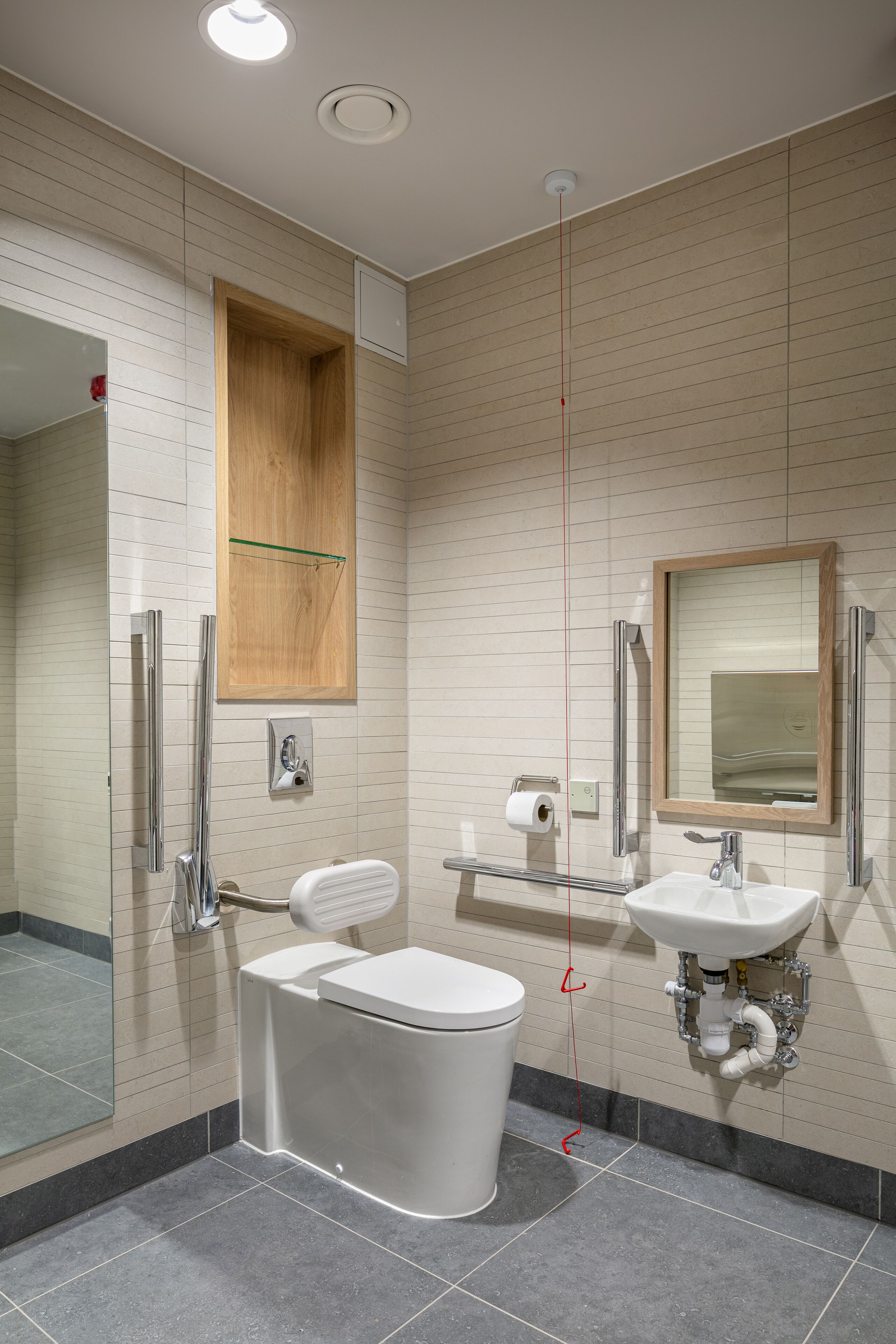 Un baño moderno con inodoro, lavamanos y ducha.