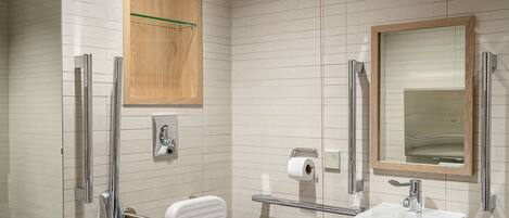 Un baño moderno con inodoro, lavamanos y ducha.