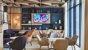 Un interior moderno con techo geométrico, una pantalla de televisión grande y una variedad de opciones de asientos.